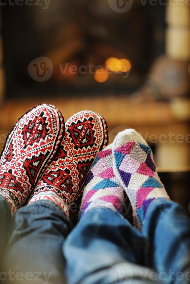 Young romantic couple sitting on sofa in front of fireplace at home photo