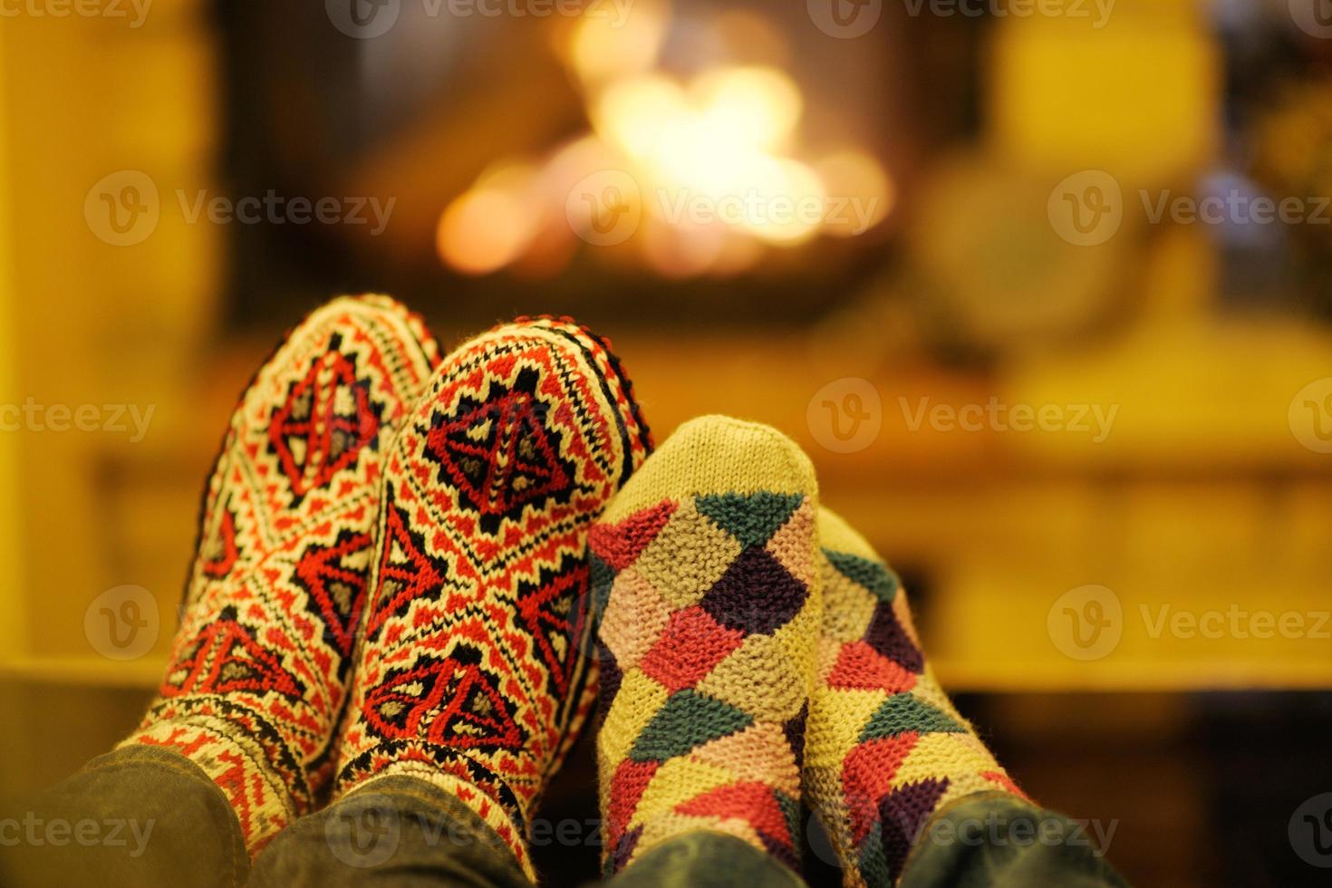 Young romantic couple sitting on sofa in front of fireplace at home photo