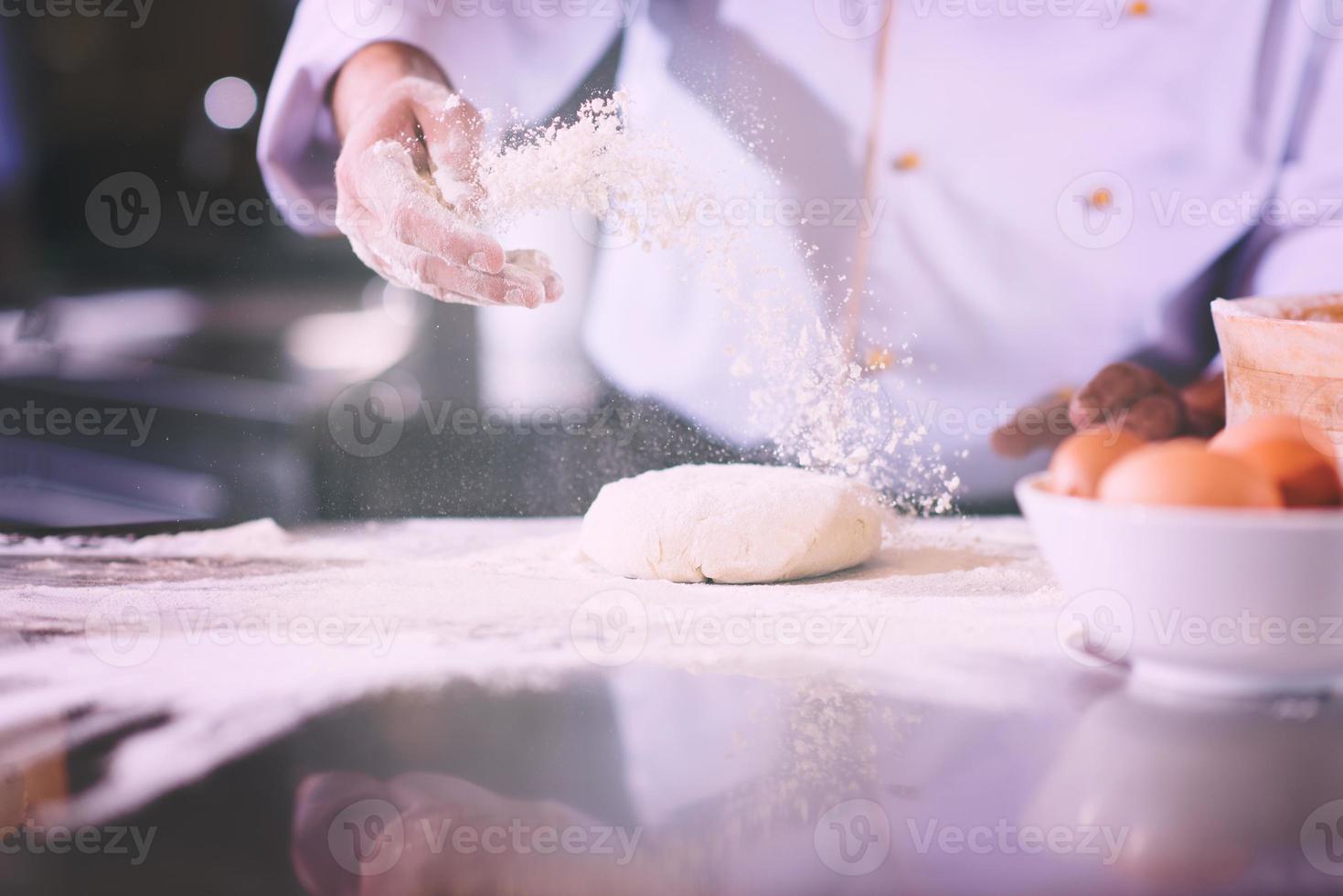 chef hands preparing dough for pizza photo