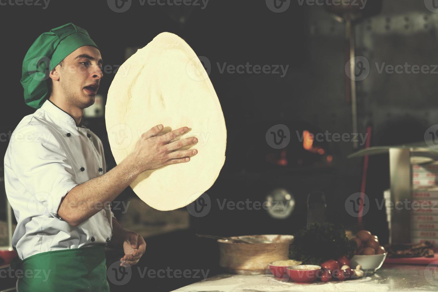 chef throwing up pizza dough photo