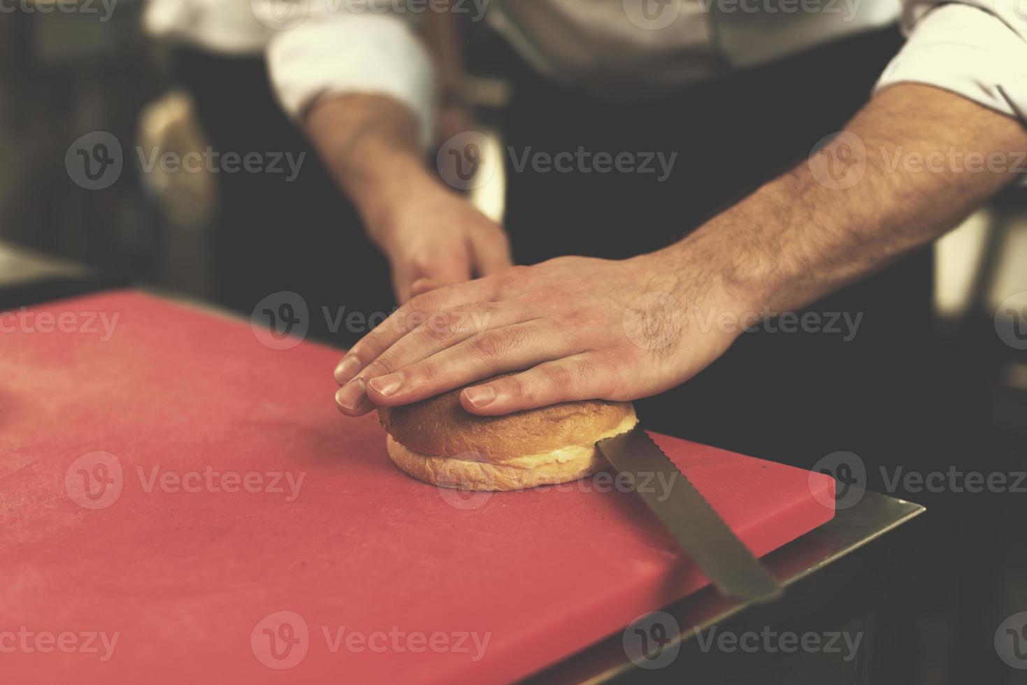 chef manos cortando rollos para hamburguesa foto