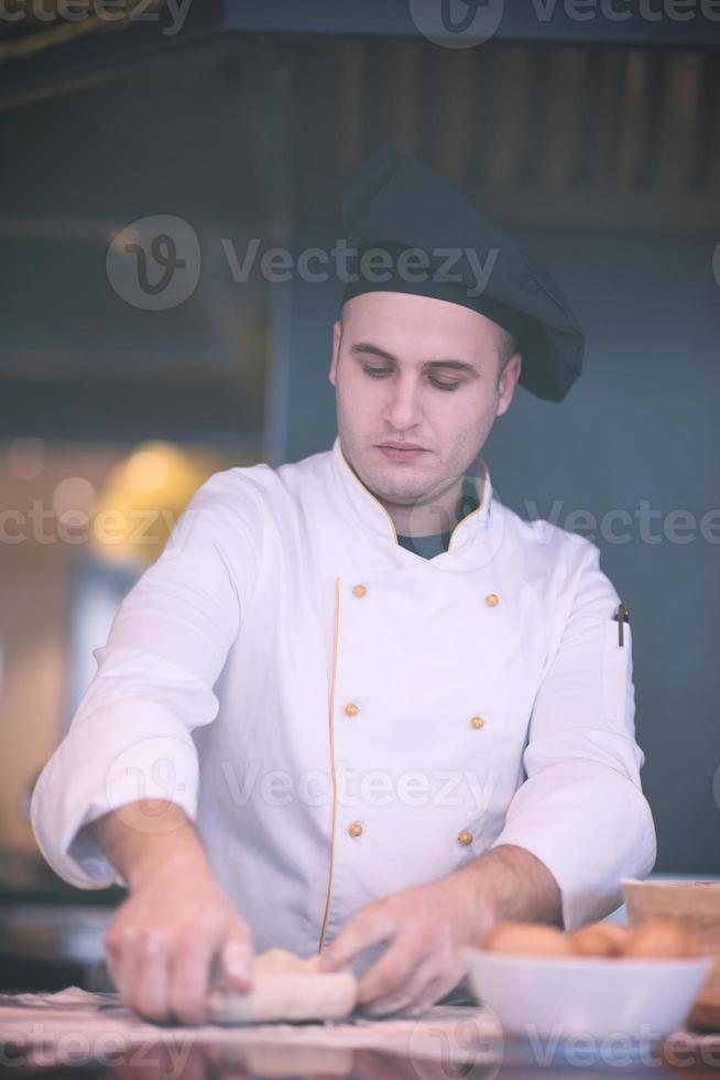 young chef preparing dough for pizza photo