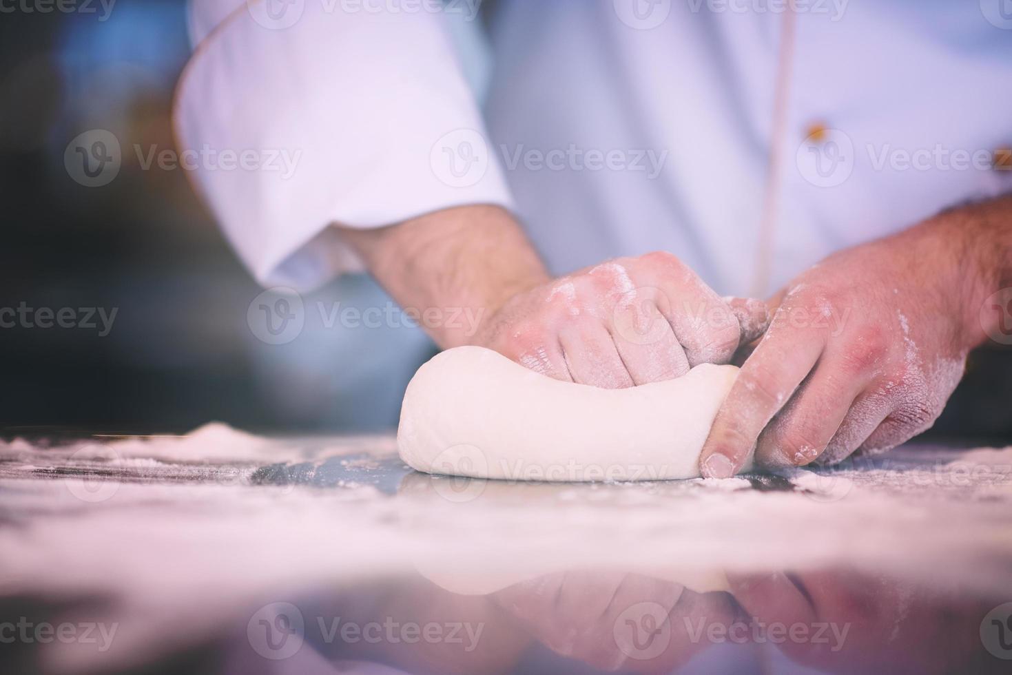 chef hands preparing dough for pizza photo