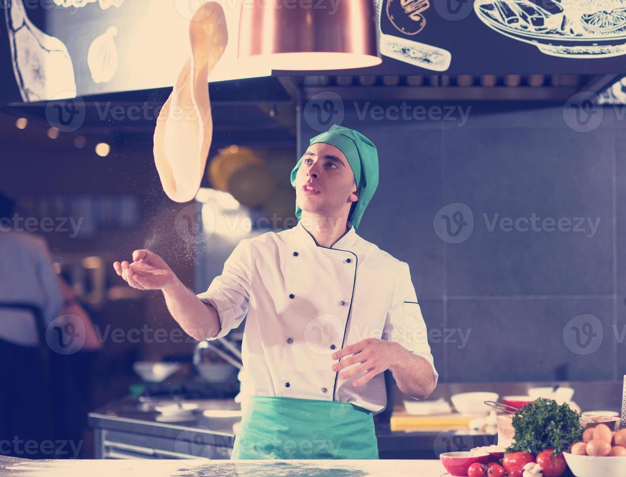 chef throwing up pizza dough photo