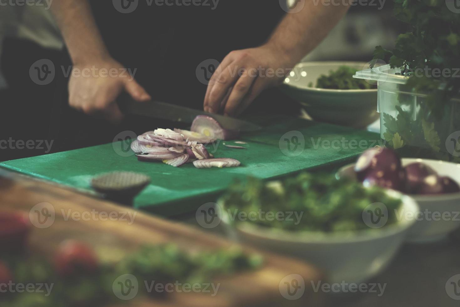 Chef  hands cutting the onion with knife photo