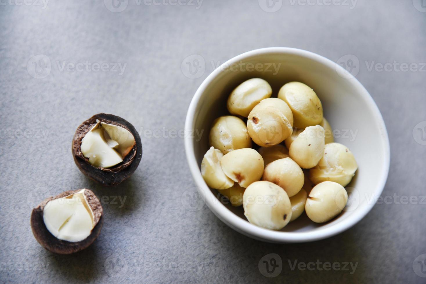 Delicious peeled Macadamia nut in a salad bowl on a gray background. The kernels of a delicious Macadamia nut close-up. photo