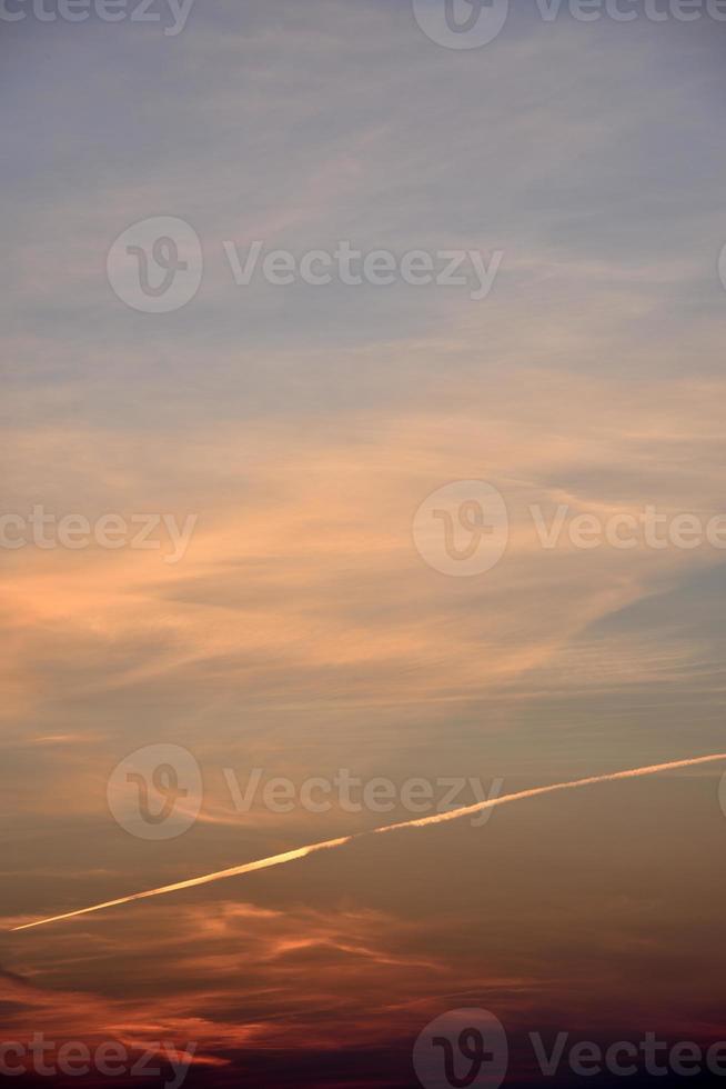 Beautiful sunset light and clouds and a trace of the plane. Evening sunset landscape in summer. photo