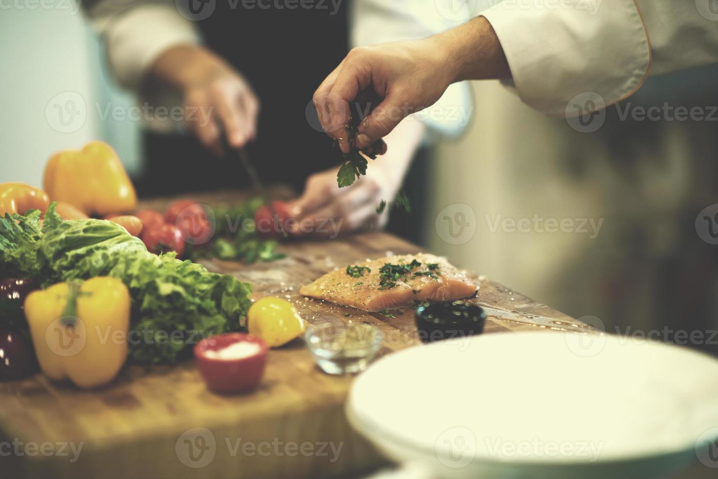 Chef hands preparing marinated Salmon fish photo