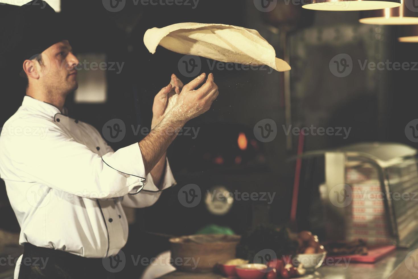 chef throwing up pizza dough photo