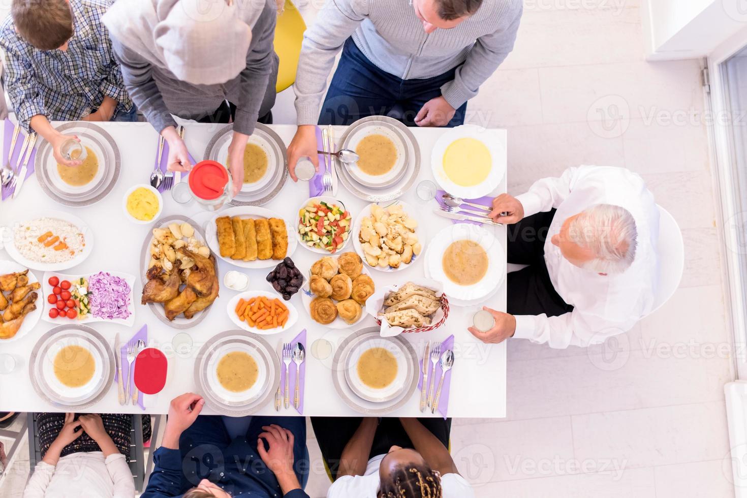 top view of modern multiethnic muslim family waiting for the beginning of iftar dinner photo