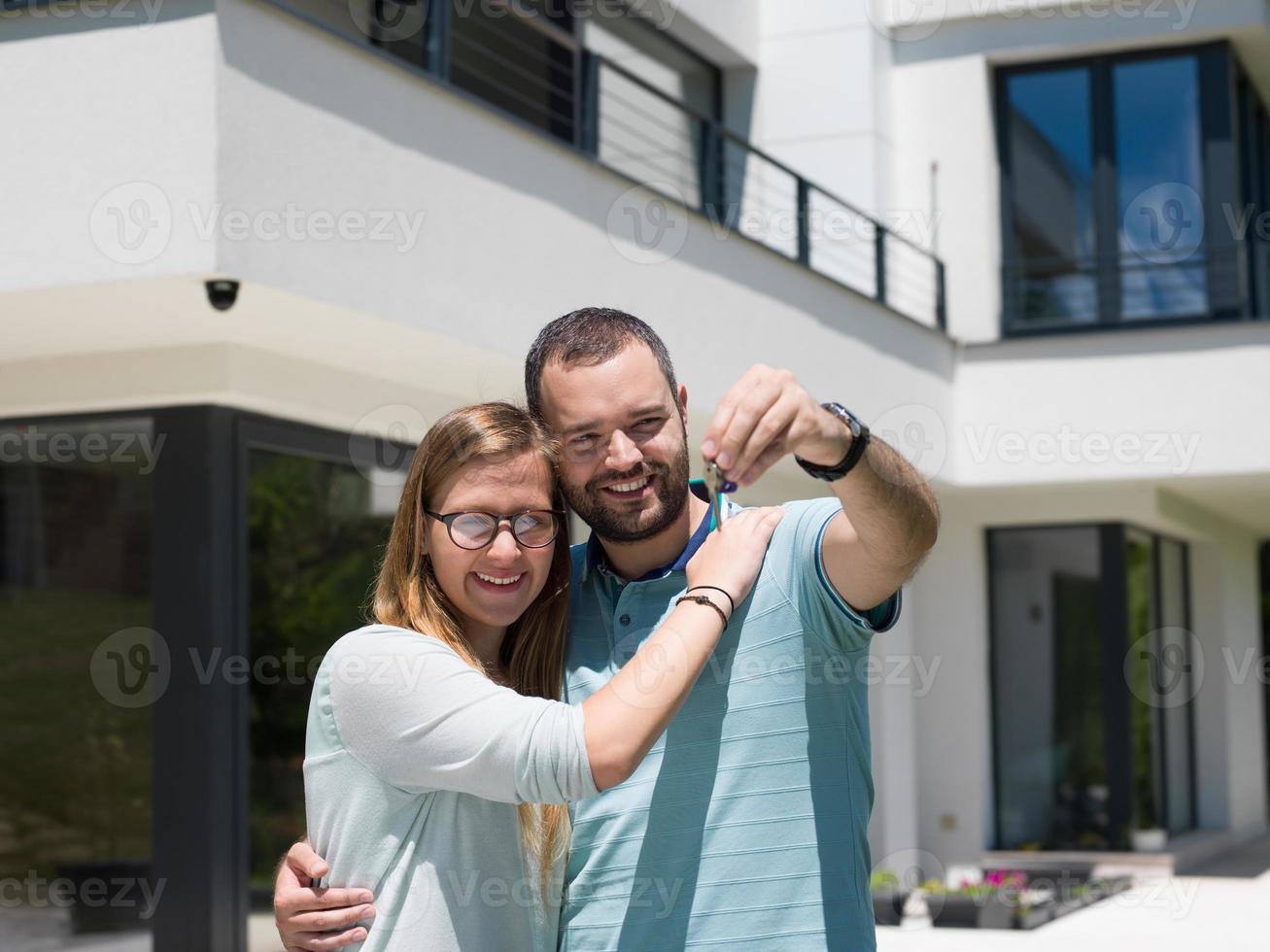 couple hugging in front of  new luxury home photo