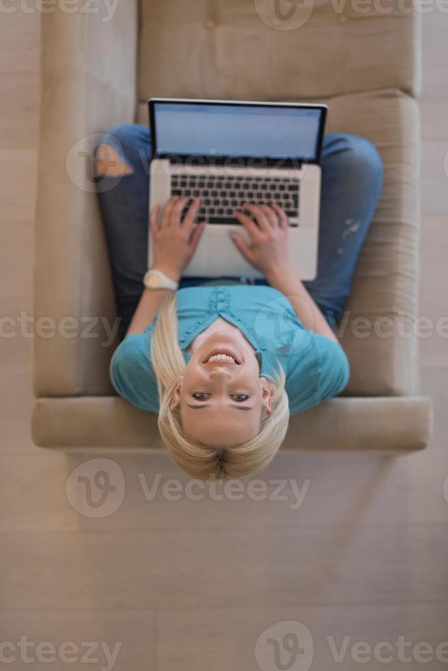 Young woman using laptop at home top view photo