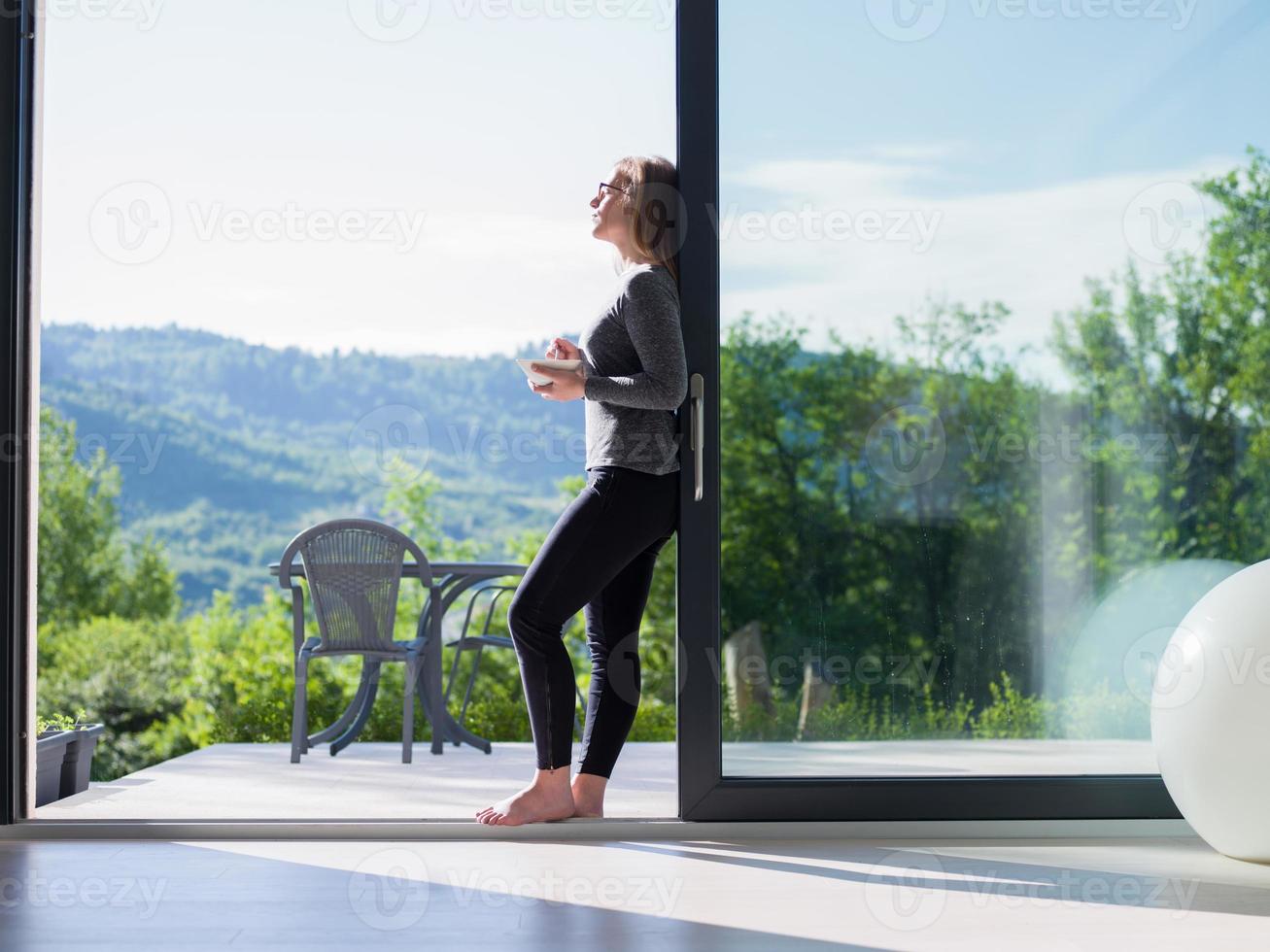 woman eating breakfast in front of her luxury home villa photo