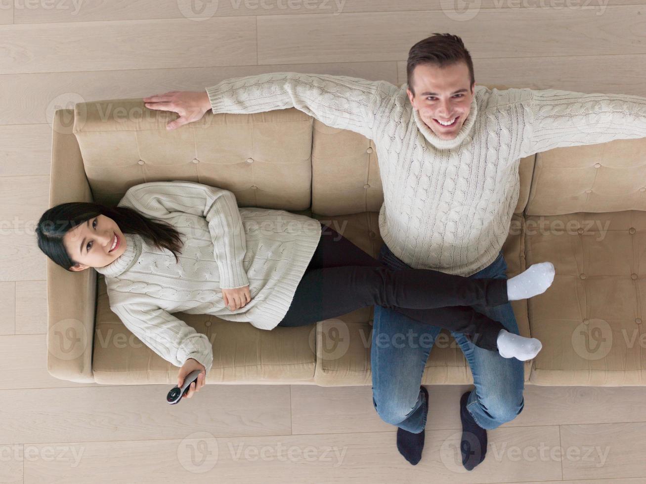 multiethnic couple on the sofa watching television photo