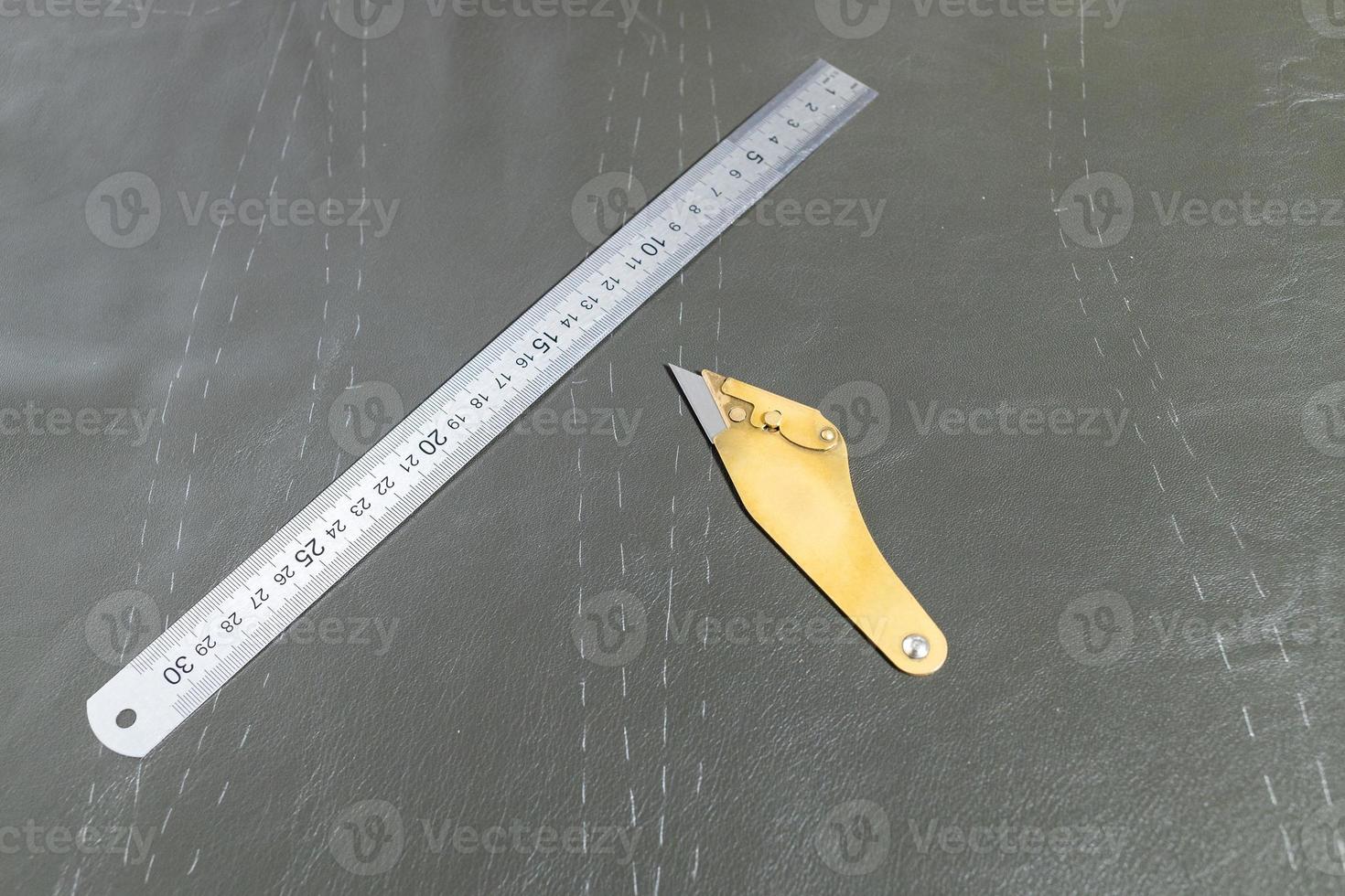 furrier knife and steel ruler on leather photo