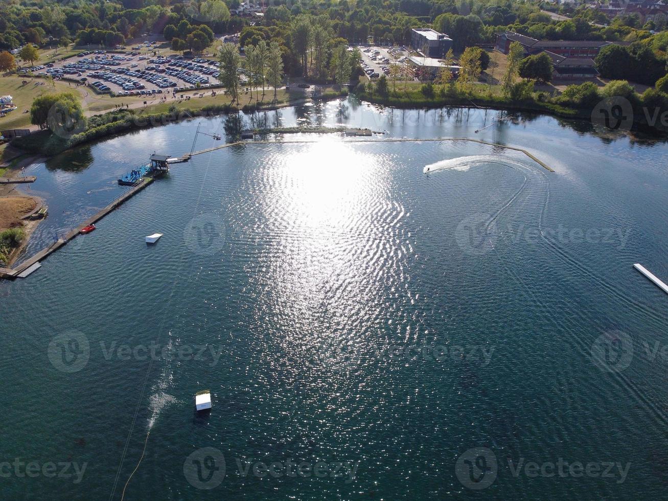 Beautiful Aerial Drone's Camera  Footage of Willen Lake and Park which is located at Milton Keynes, England. People are Enjoying at Lake on a Hot Sunny Day of Summer photo