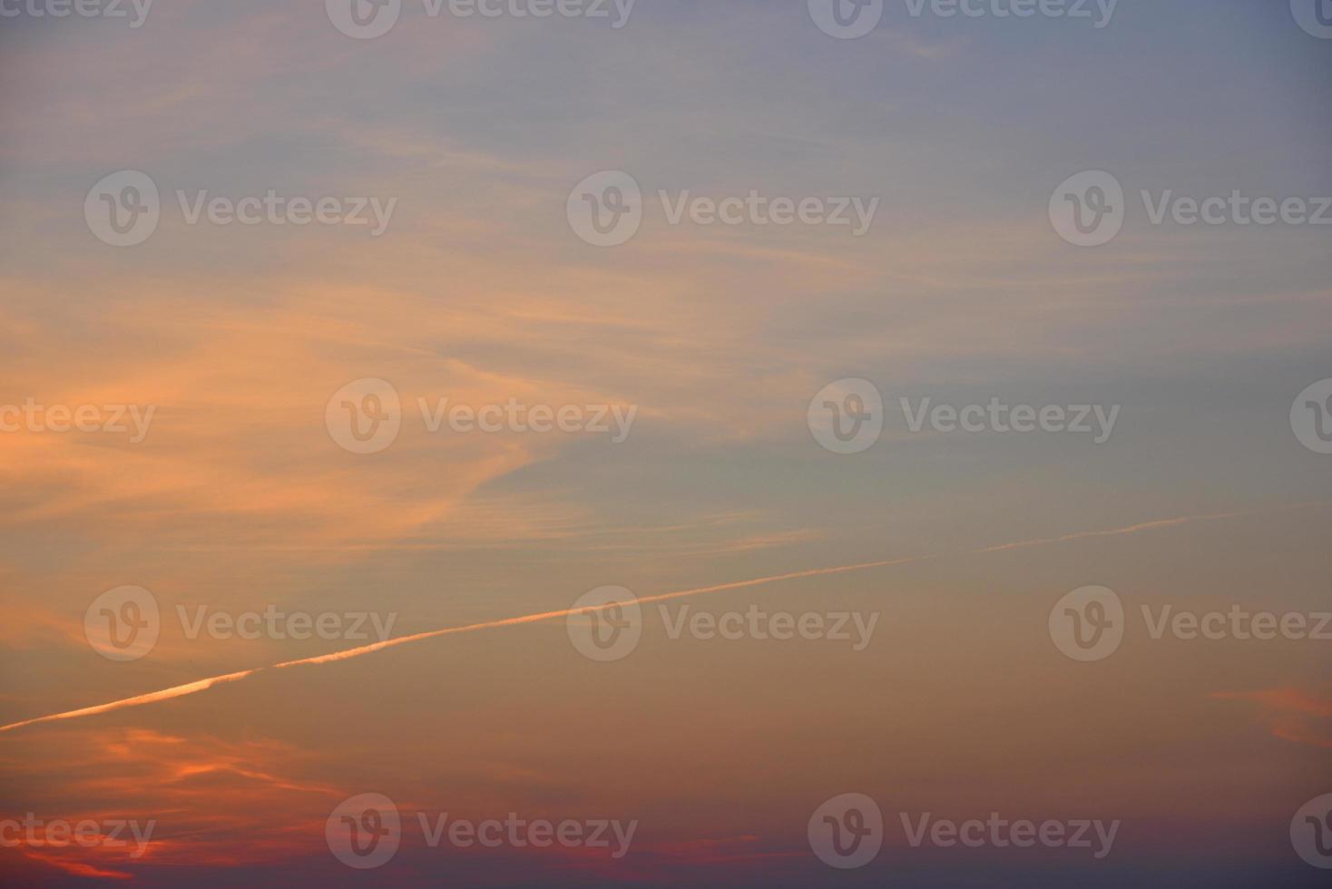 Beautiful sunset light and clouds and a trace of the plane. Evening sunset landscape in summer. photo