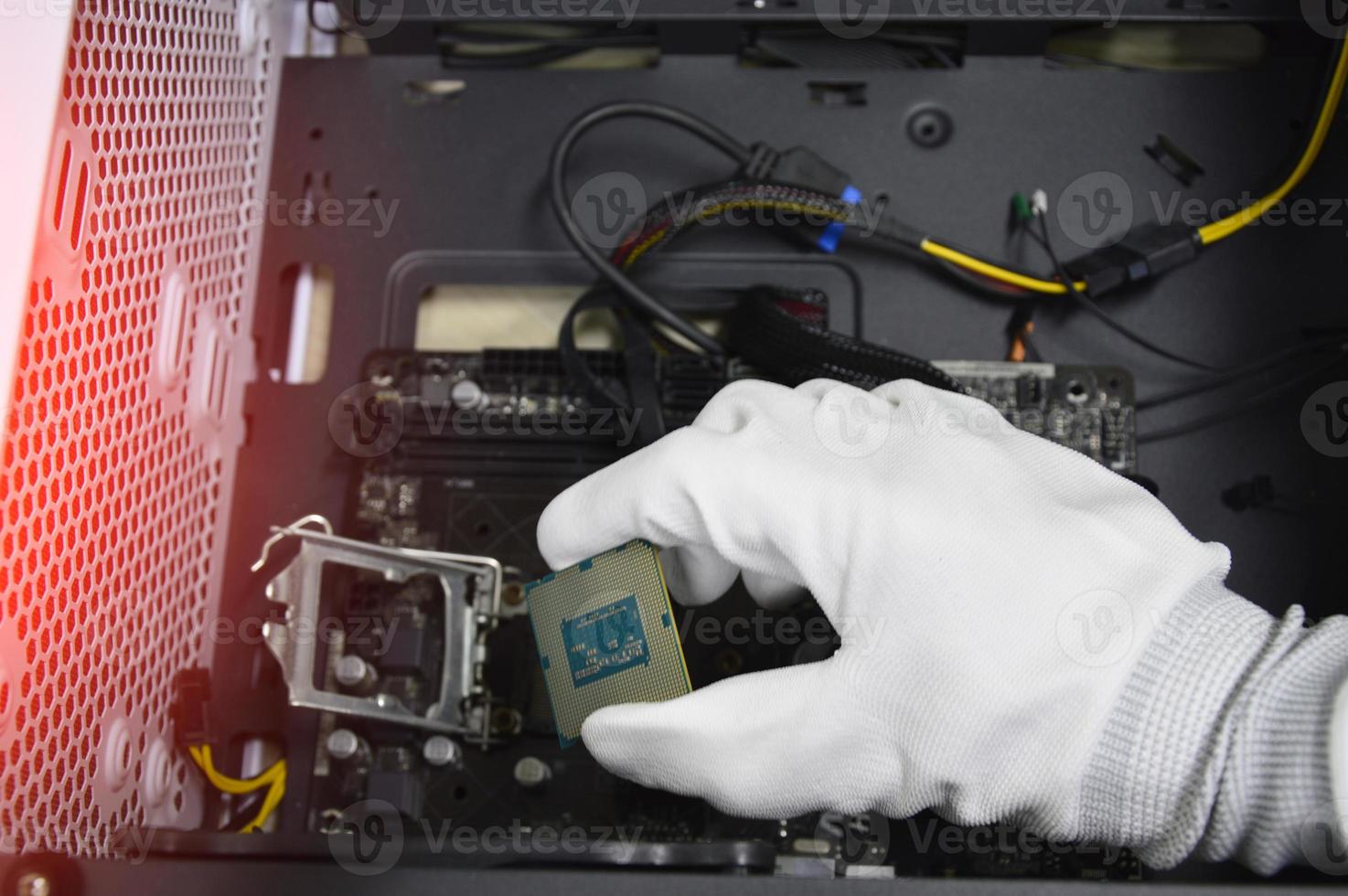 Image of a technician inserting a CPU chip onto a computer motherboard. photo