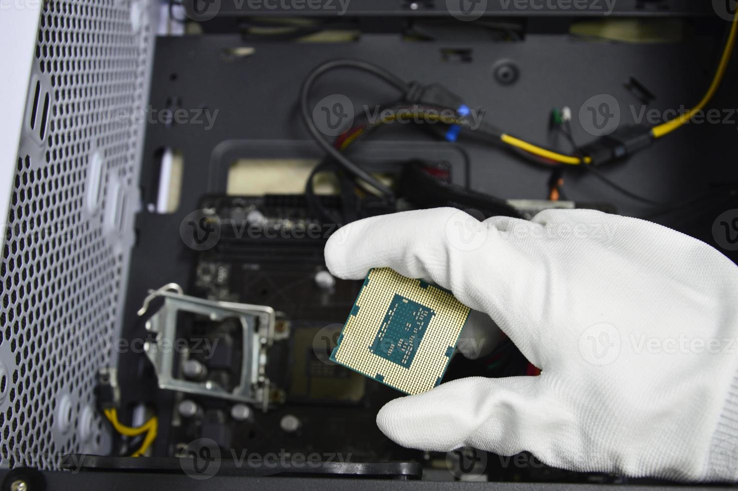Image of a technician inserting a CPU chip onto a computer motherboard. photo