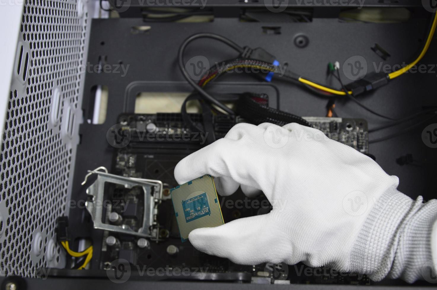 imagen de un técnico insertando un chip de CPU en la placa base de una computadora. foto