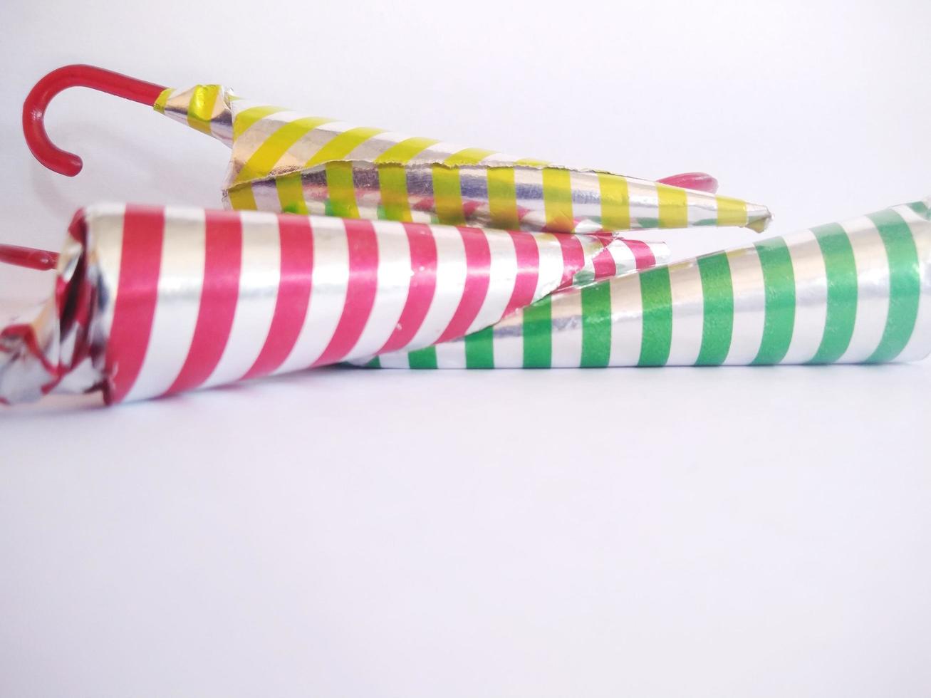 chocolate shaped like an umbrella wrapped in aluminum foil with a strip motif. isolated on a white background.close up. photo