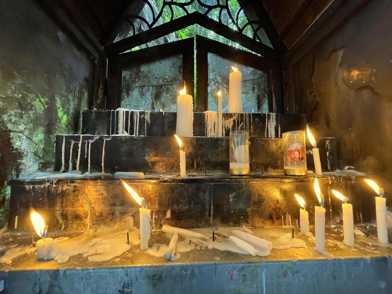 un montón de oraciones, las llamas de las velas que brillan en la oscuridad crean una atmósfera espiritual foto