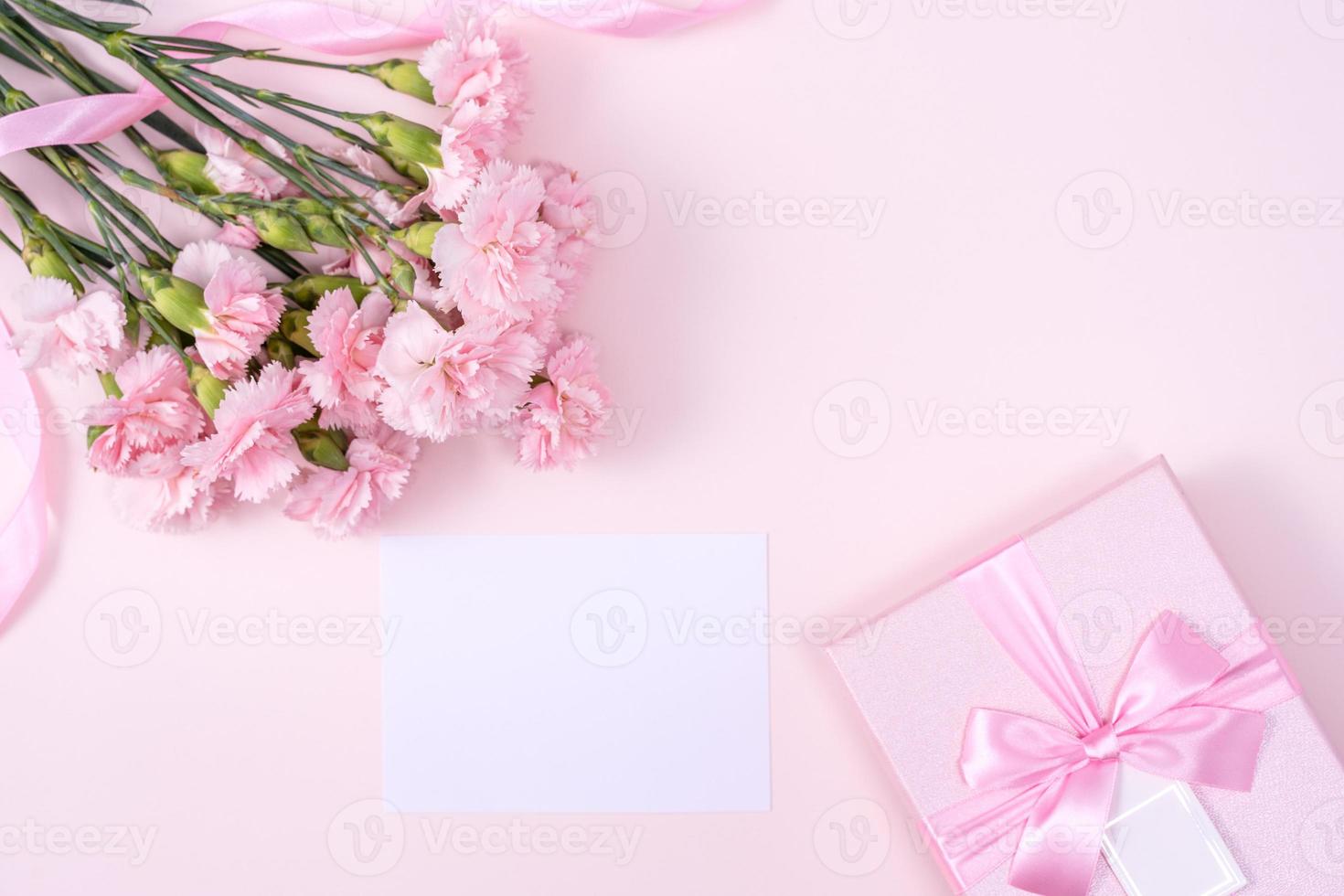 día de la madre, concepto de diseño de fondo del día de San Valentín, hermoso ramo de flores de clavel rosa en una mesa rosa pastel, vista superior, puesta plana, espacio para copiar. foto