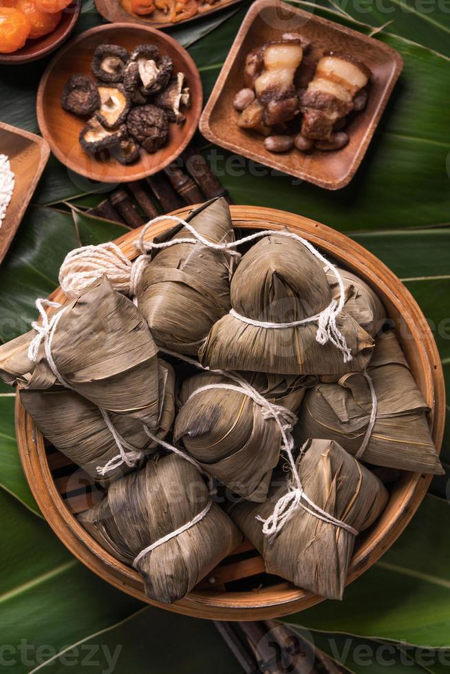 Rice dumpling, zongzi - Traditional Chinese food on green leaf background of Dragon Boat Festival, Duanwu Festival, top view, flat lay design concept. photo