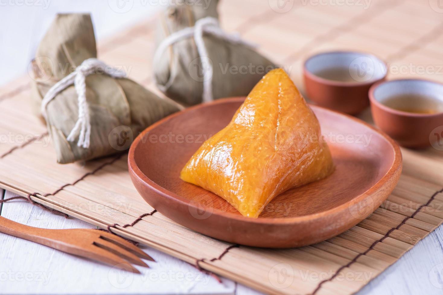 Zongzi - Alkaline rice dumpling - Traditional sweet Chinese crystal food on a plate to eat for Dragon Boat Duanwu Festival celebration concept, close up. photo