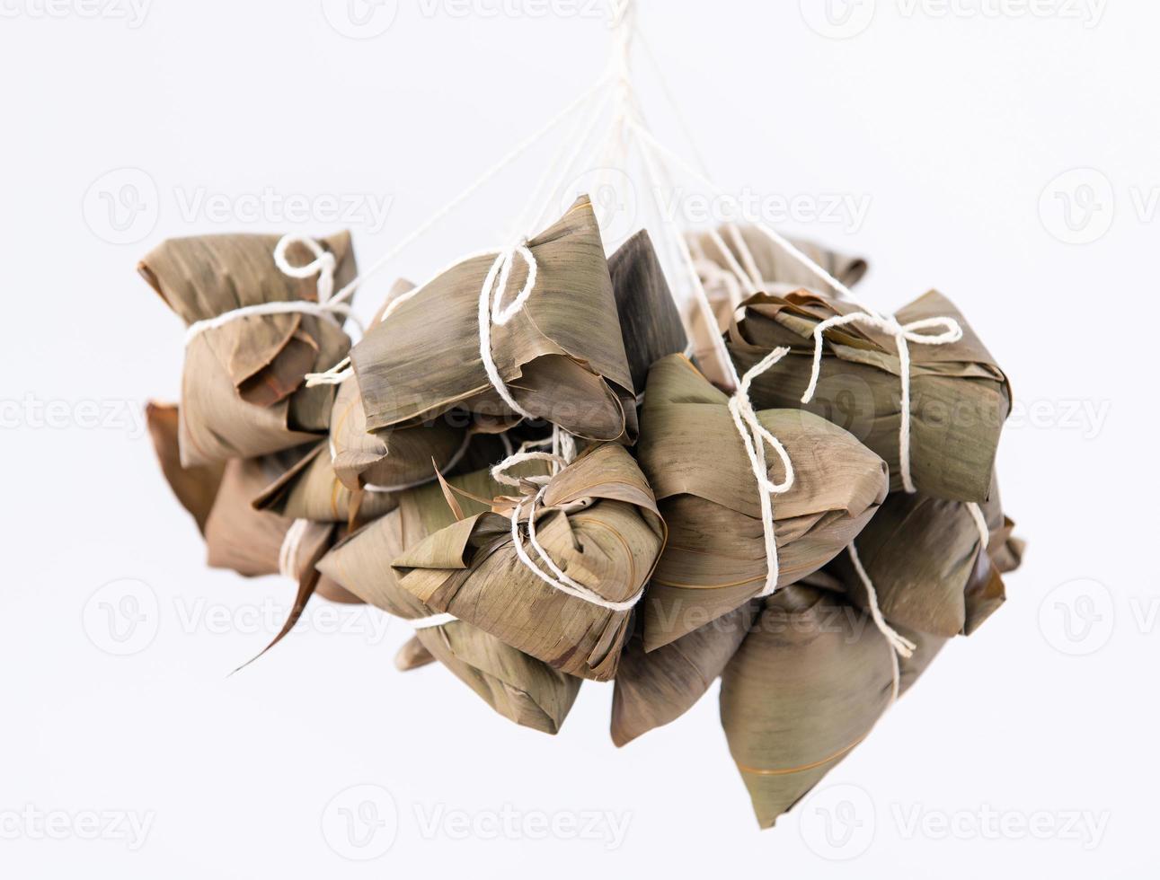 Rice dumpling zongzi making - wrapping Chinese rice dumpling zongzi on table at home for Dragon Boat Festival celebration, close up, lifestyle. photo