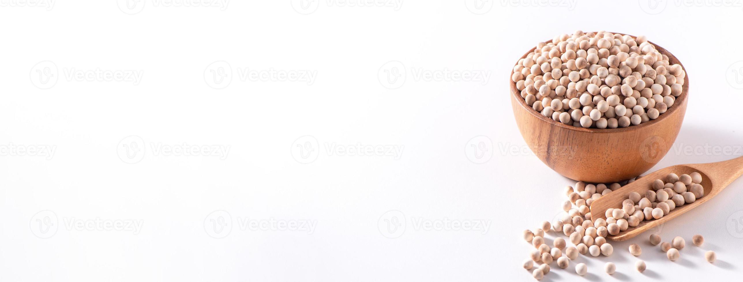 Dry raw brown tapioca pearls in a wooden bowl with spoon isolated on white background, close up, ingredient of making bubble boba milk tea. photo