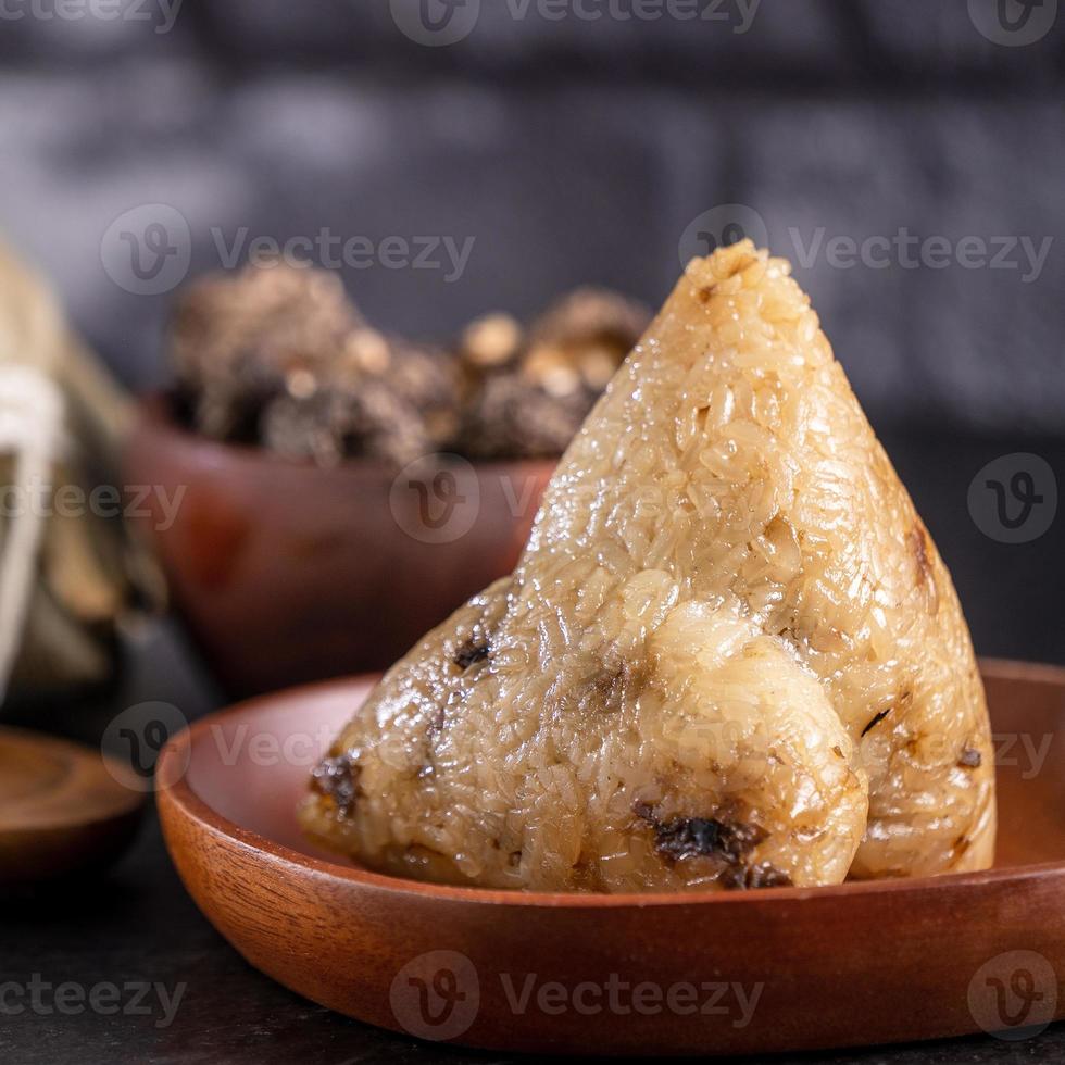 Rice dumpling, zongzi - Chinese rice dumpling zongzi on black brick background slate table, concept of Dragon Boat Festival traditional food, close up. photo