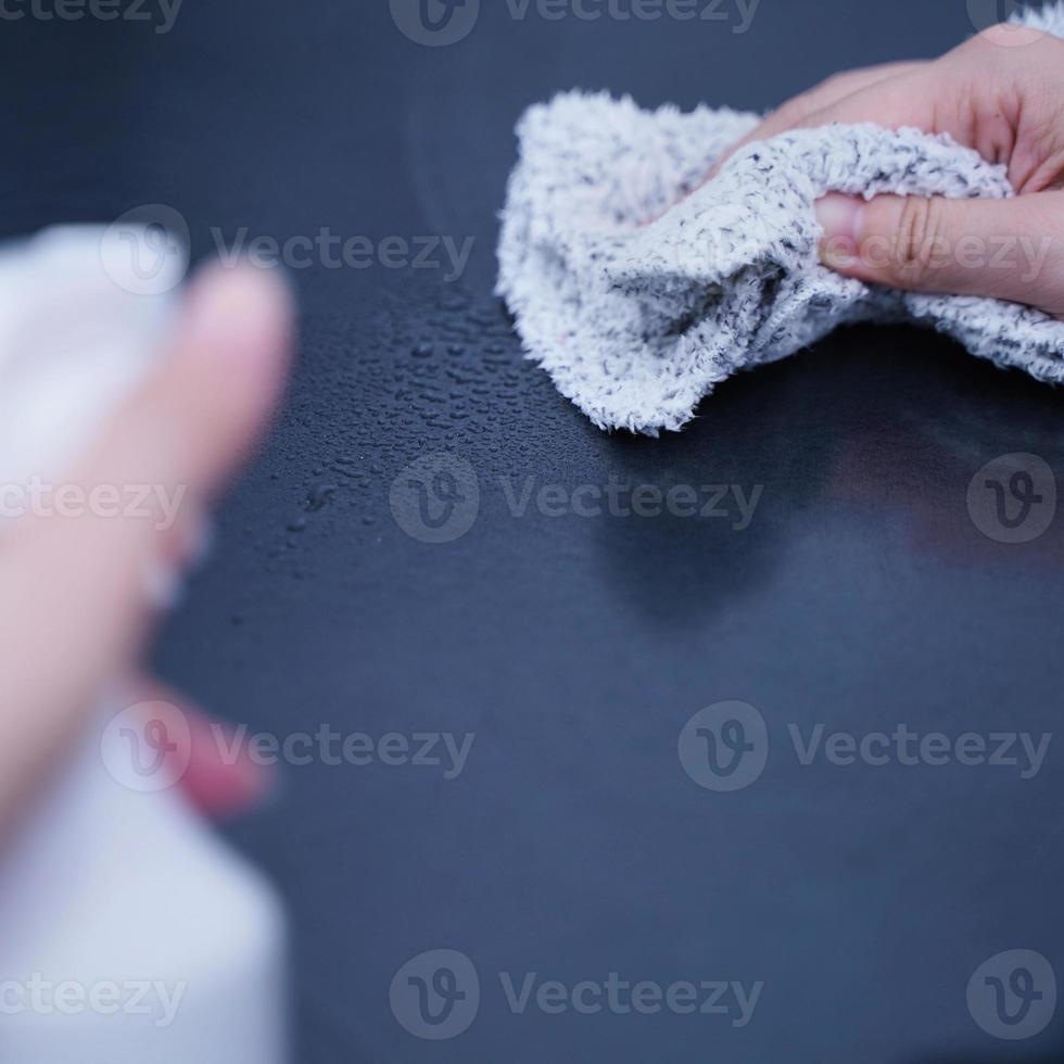 Young woman is holding spray bottle, rag to clean, wipe down office metal cabinet shelf accommodation surface, close up, lifestyle, concept of antibacterial. photo