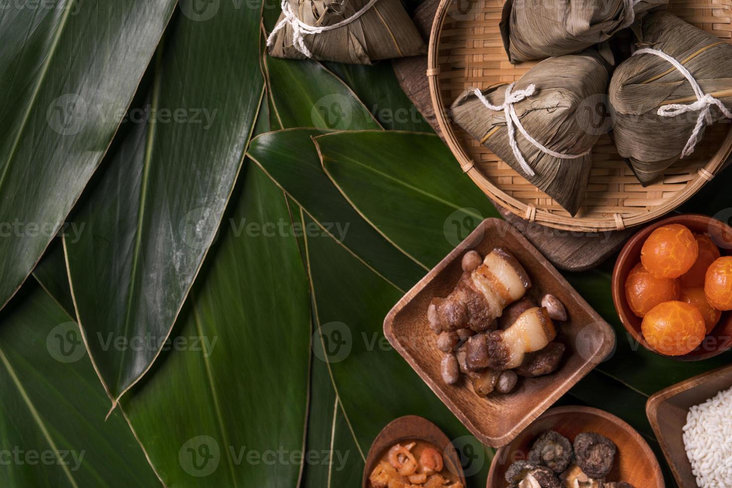 Rice dumpling, zongzi - Traditional Chinese food on green leaf background of Dragon Boat Festival, Duanwu Festival, top view, flat lay design concept. photo