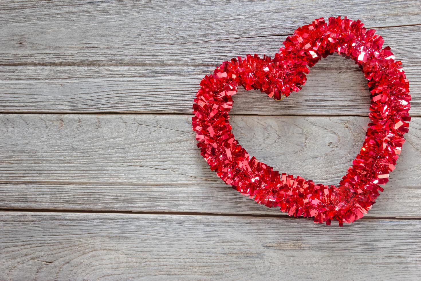 Tinsel heart  decoration on wood background photo