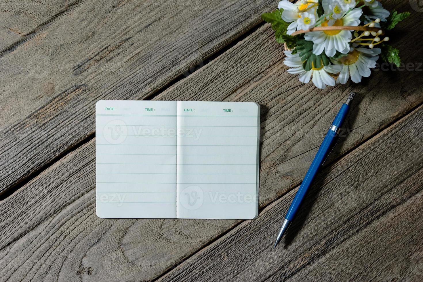 open note book with clutch-type pencil on wood background photo