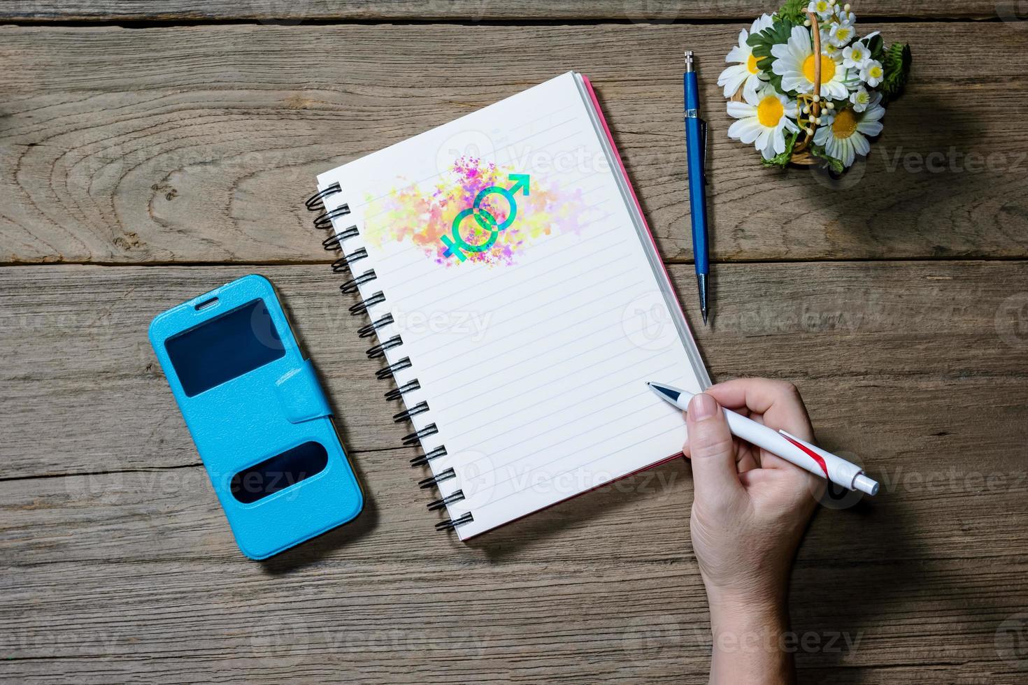 Human hand holding pen with open note book photo