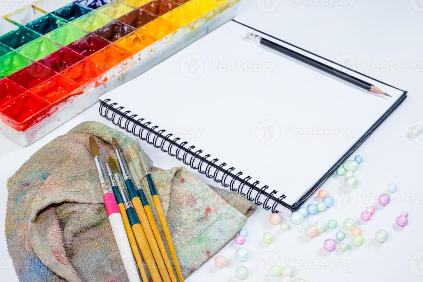 closeup open note book with tray colors on background photo