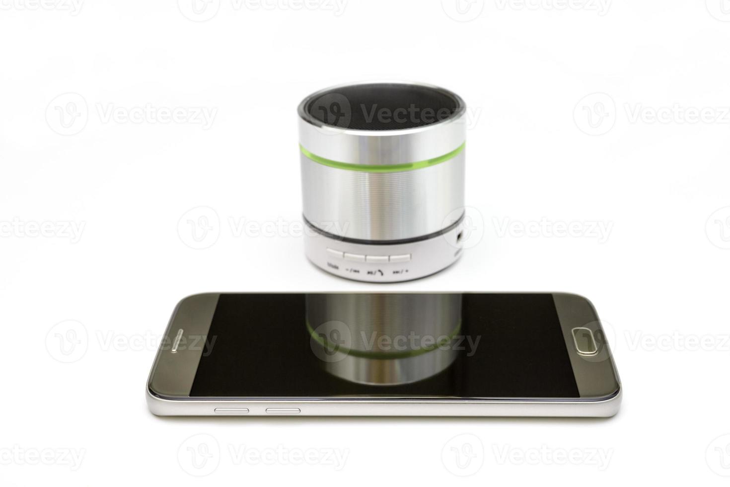 cellphone and silver bluetooth speaker isolated on white background photo
