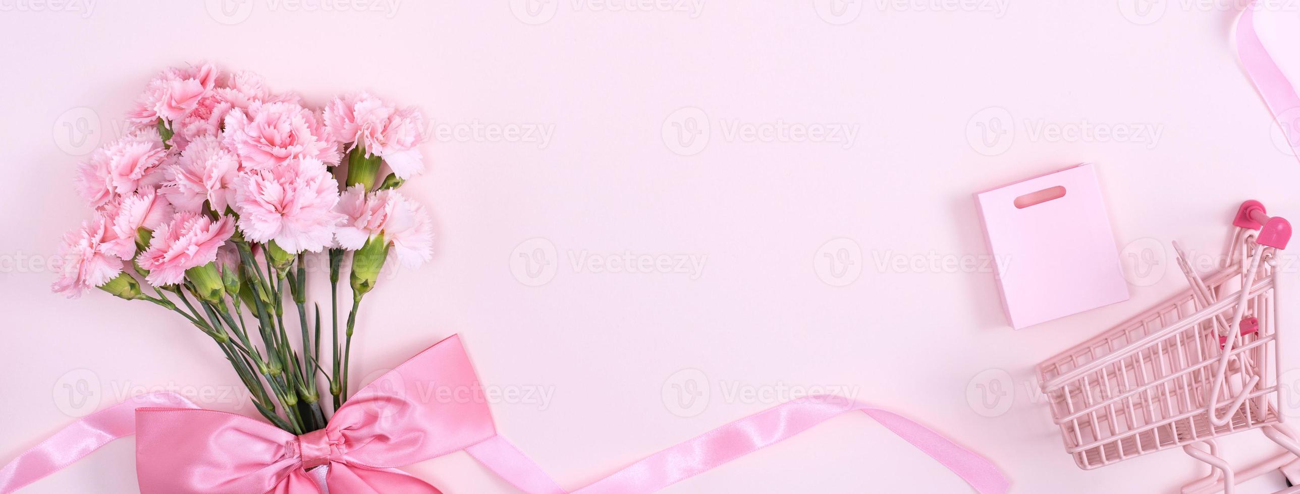 día de la madre, concepto de diseño de fondo del día de San Valentín, hermoso ramo de flores de clavel rosa en una mesa rosa pastel, vista superior, puesta plana, espacio para copiar. foto