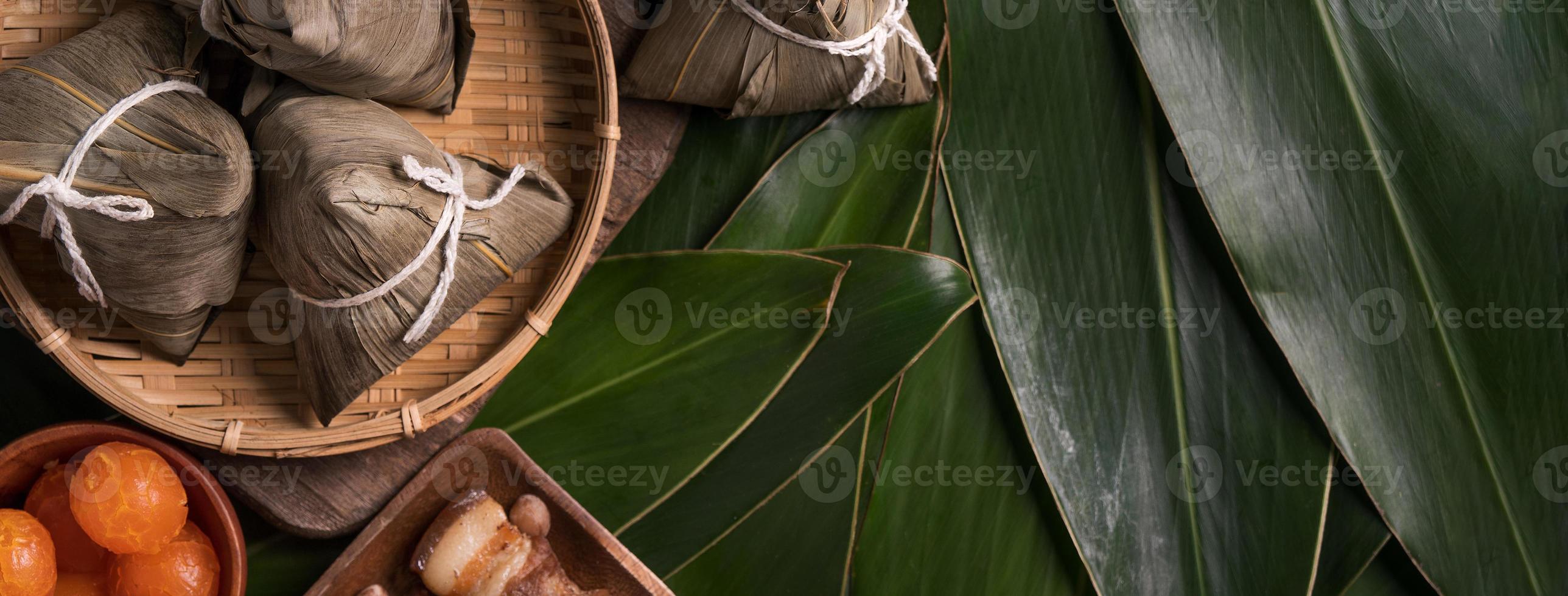 Rice dumpling, zongzi - Traditional Chinese food on green leaf background of Dragon Boat Festival, Duanwu Festival, top view, flat lay design concept. photo