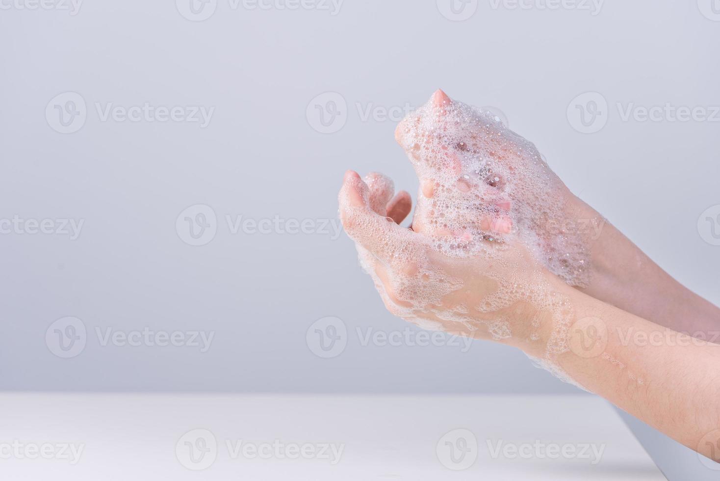Washing hands. Asian young woman using liquid soap to wash hands, concept of hygiene to protective pandemic coronavirus isolated on gray white background, close up. photo