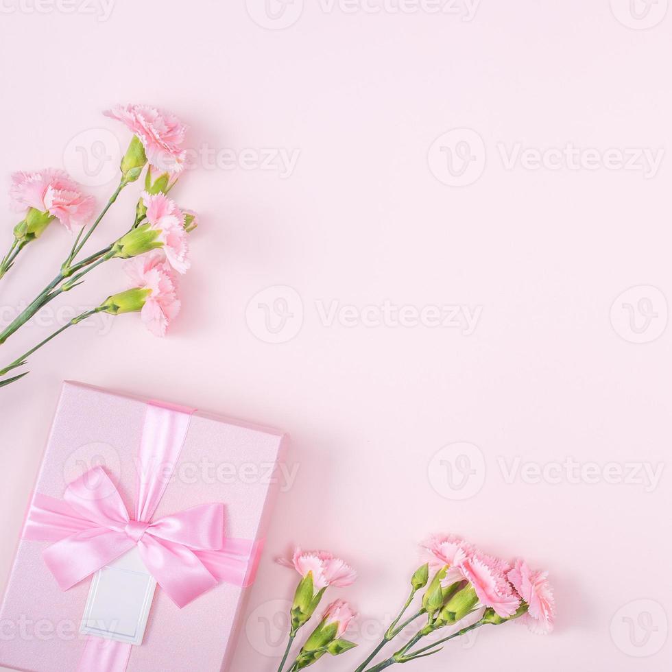 día de la madre, concepto de diseño de fondo del día de San Valentín, hermoso ramo de flores de clavel rosa en una mesa rosa pastel, vista superior, puesta plana, espacio para copiar. foto