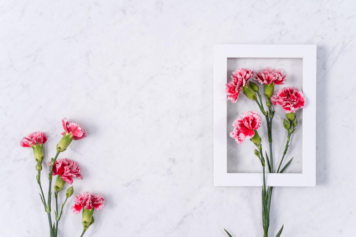 día de la madre, concepto de diseño de fondo del día de San Valentín, hermoso ramo de flores de clavel rosa y rojo en la mesa de mármol, vista superior, puesta plana, espacio de copia. foto