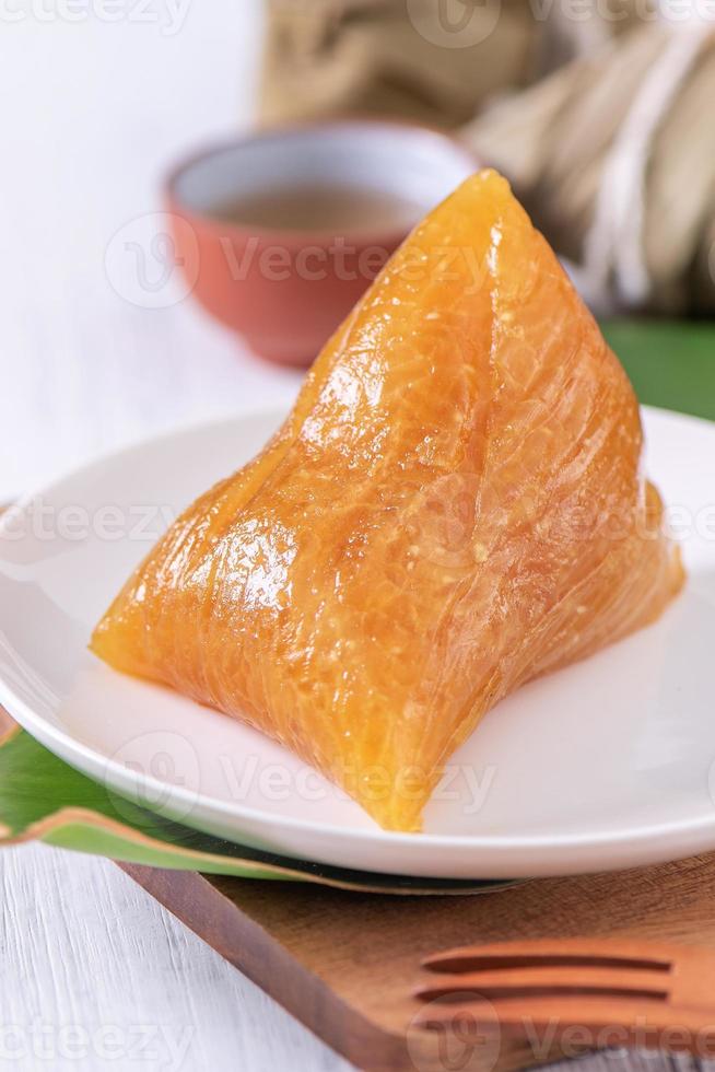 Alkaline rice dumpling zongzi - Traditional sweet Chinese crystal food on a plate to eat for Dragon Boat Duanwu Festival celebration concept, close up. photo