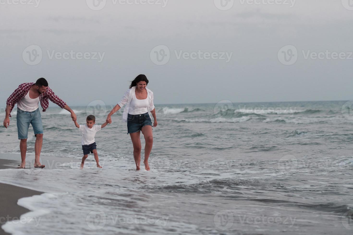 Happy young family have fun and live healthy lifestyle on beach. Selective focus photo