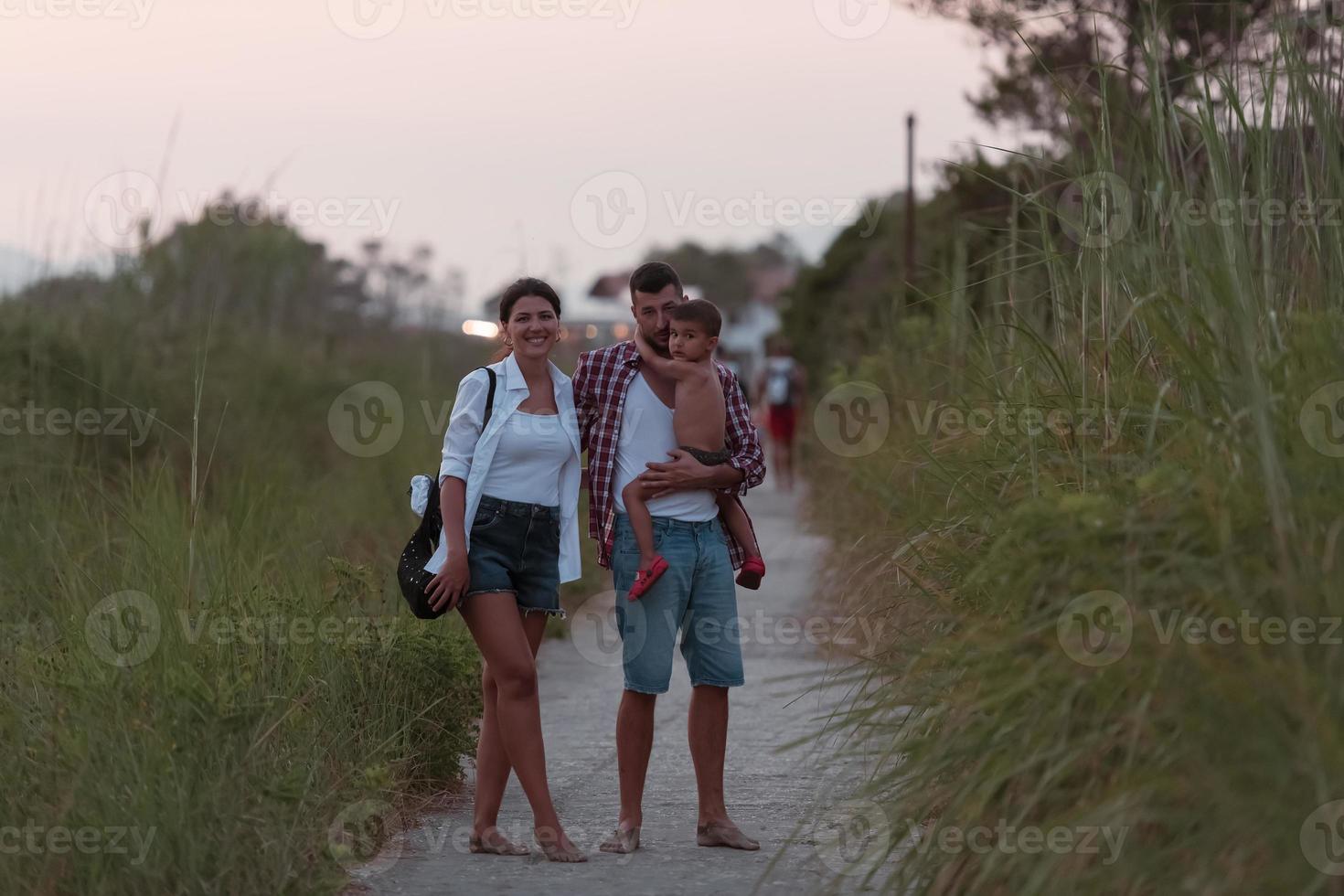 The family walks an idyllic path surrounded by tall grass. Selective focus photo
