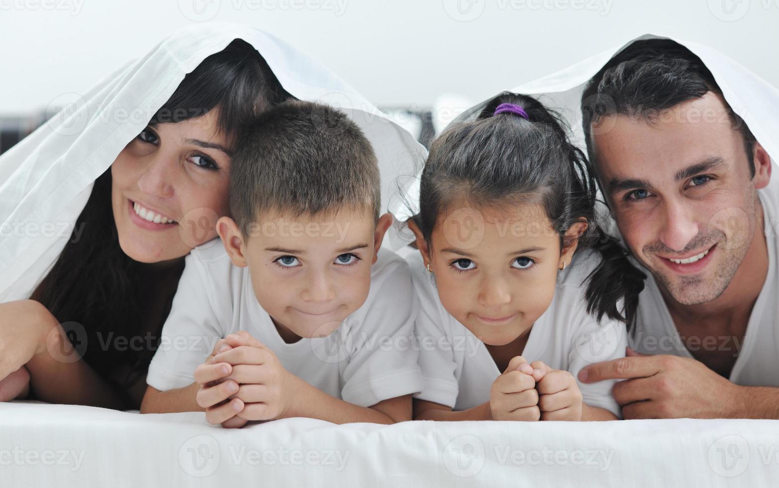 familia joven feliz en su dormitorio foto