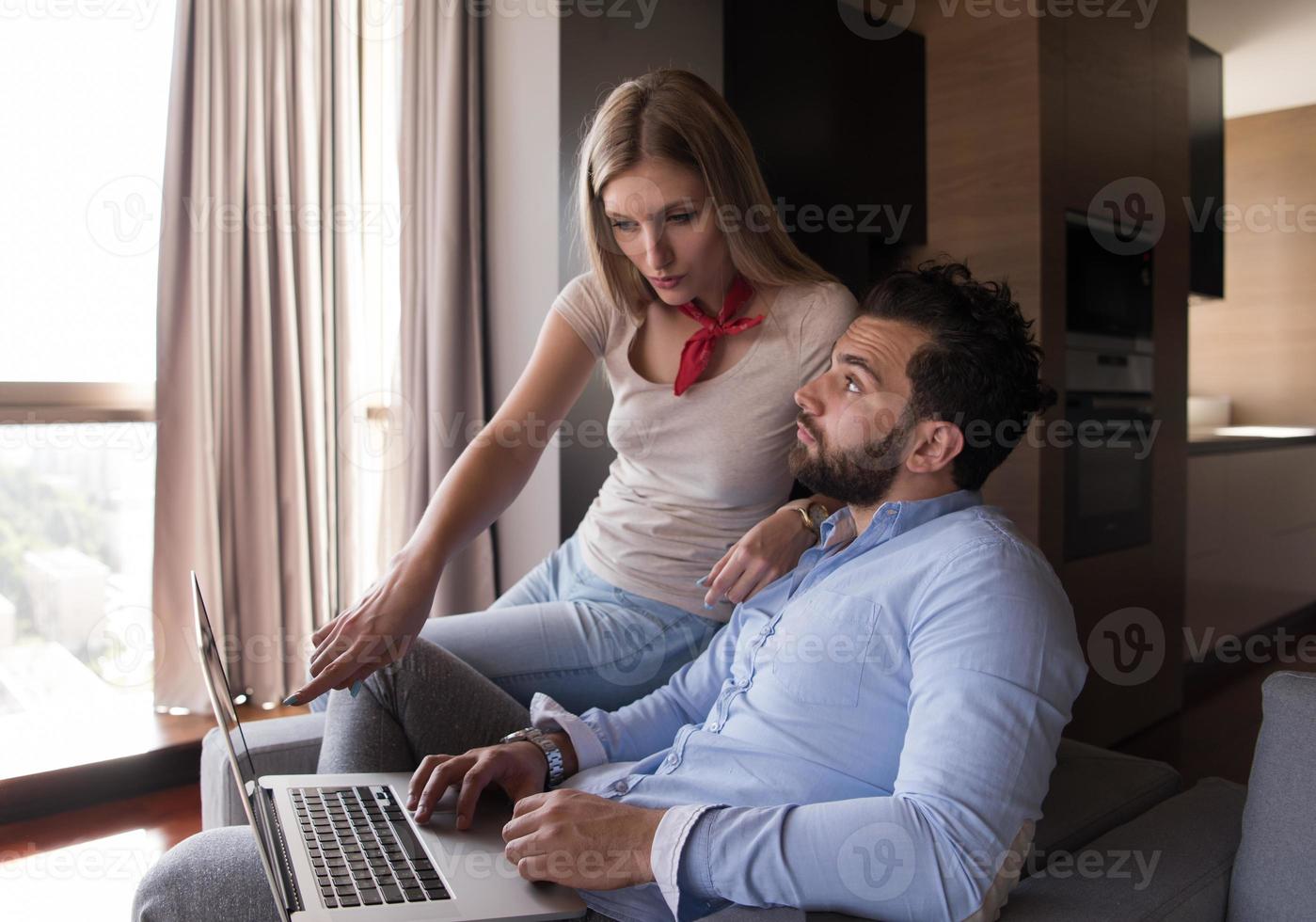 couple relaxing at  home using laptop computers photo