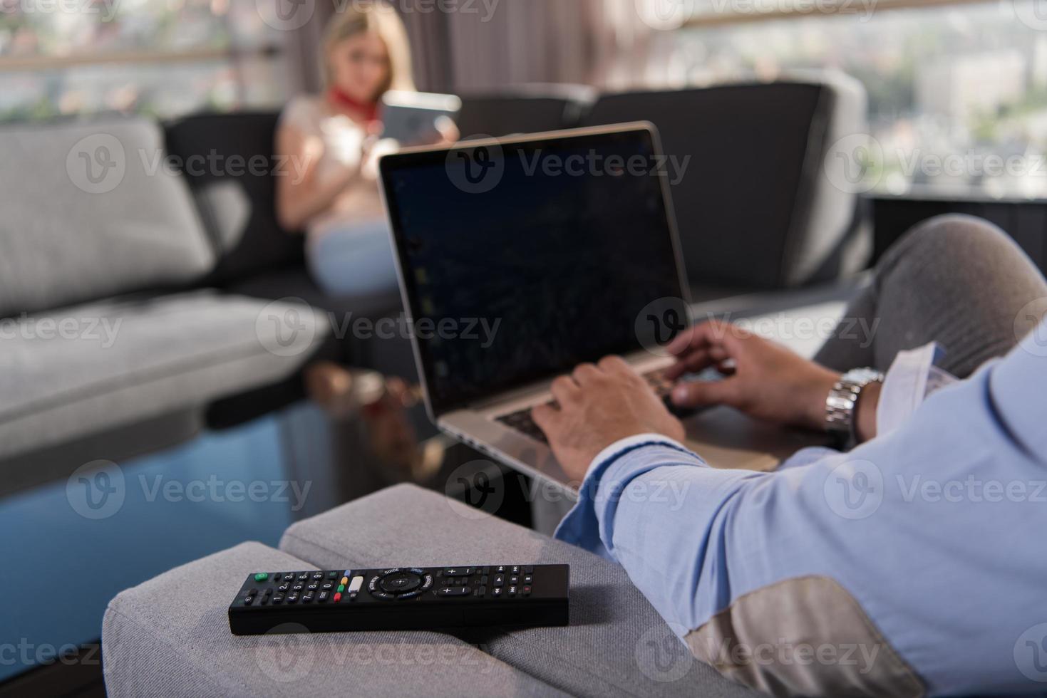couple relaxing at  home using tablet and laptop computers photo